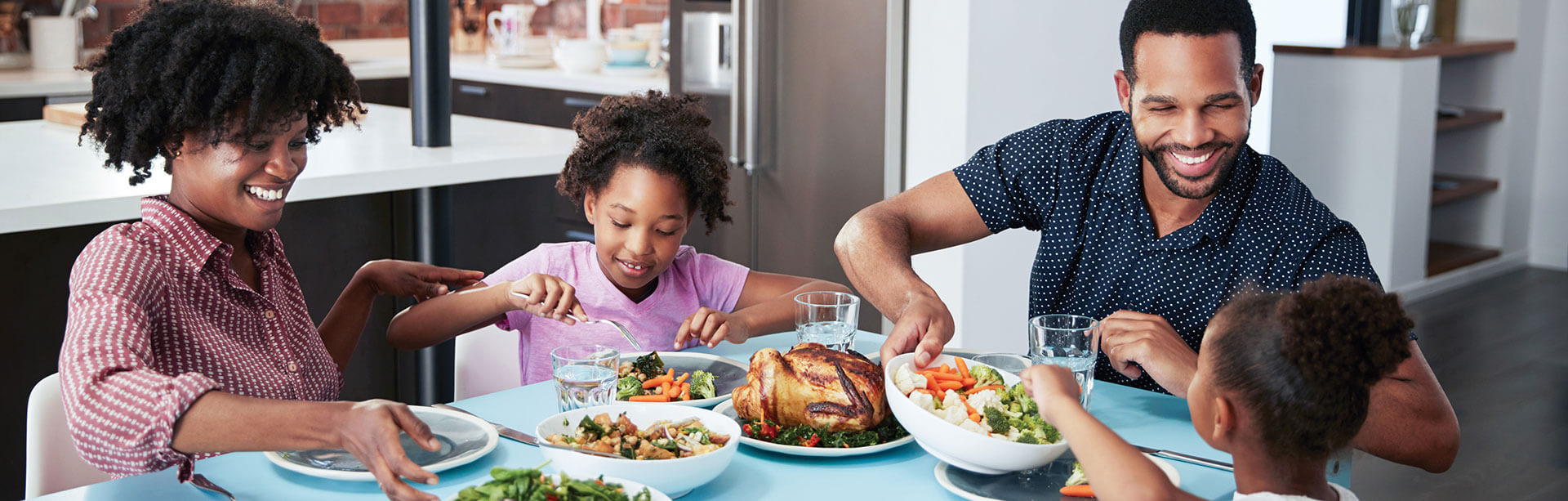 bac mom and toddler eating veggie smiling