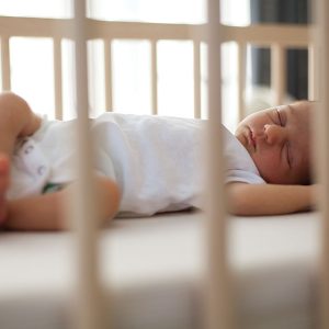 Newborn baby sleeping safely in a crib